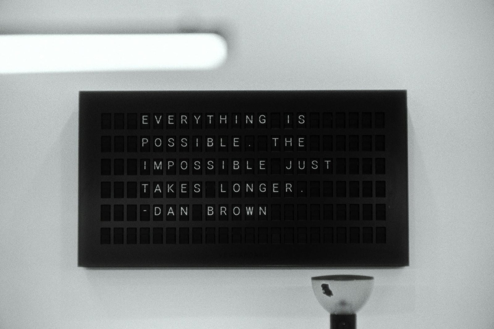 A letterboard sign reading everything is possible, the impossible just takes longer