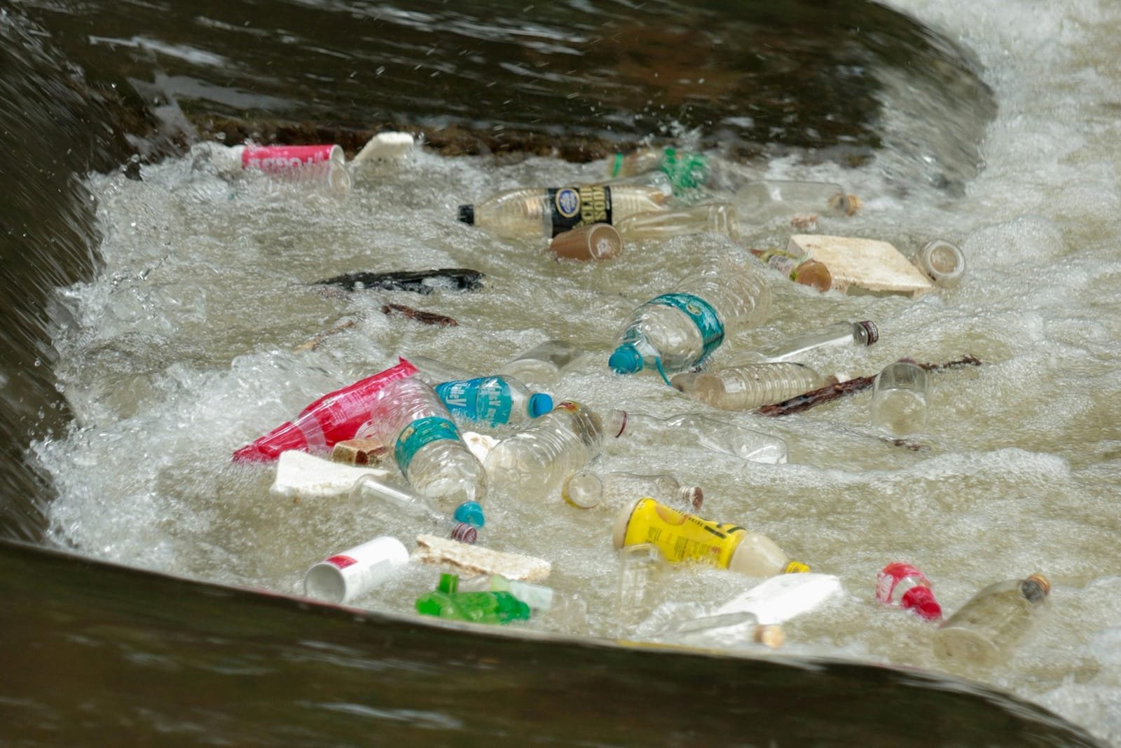 Plastic waste caught in a weir on a river