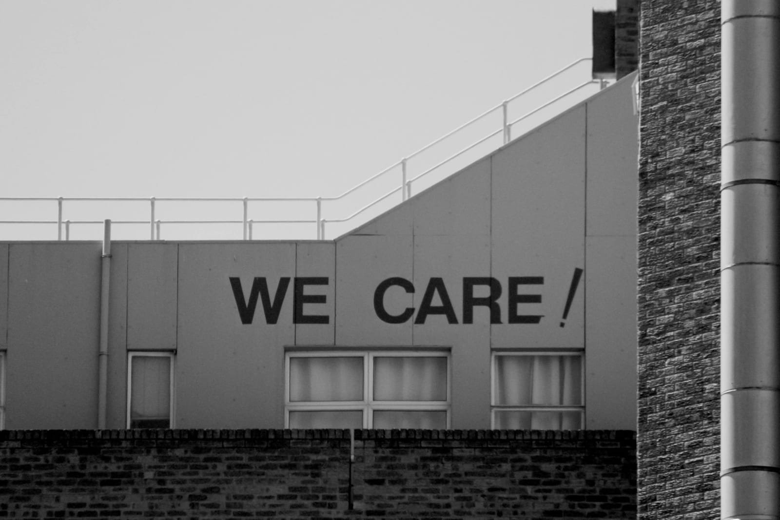 The words WE CARE painted across an industrial facade